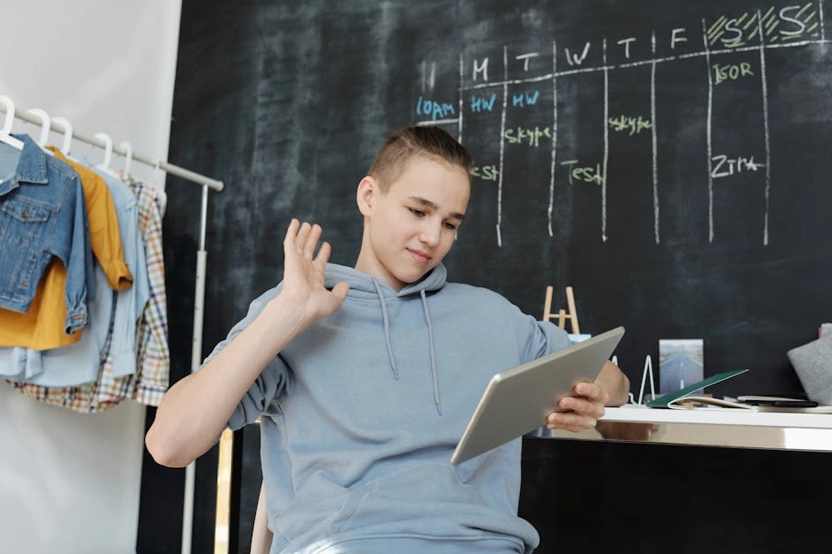 Una persona che studia finanza online dal proprio tablet, seduta comodamente su un divano.